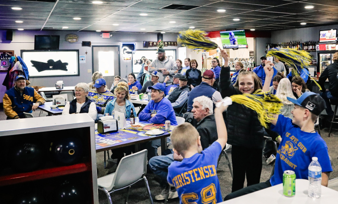 In the foreground, Cecil Fagerhaug, Carlayna Waters and Casen Waters celebrate and get the crowd revved up at Sunday’s watch party at Pin Twisters.