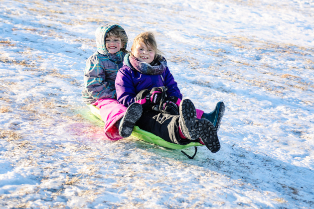 Sabrina Schaller and Memphis Hanson zip down the sledding hill Sunday. T