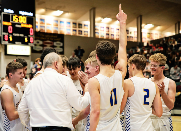 Coach Kenny Huether celebrates with the Spartans after the win at the Corn Palace.