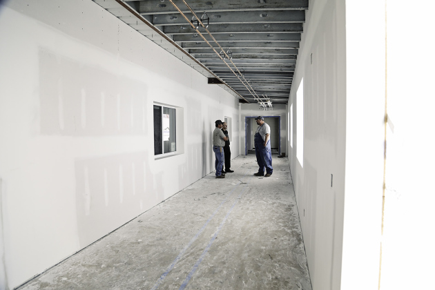 Members of the building committee are shown in one of the connecting corridors between the elementary school building and new facility. 
