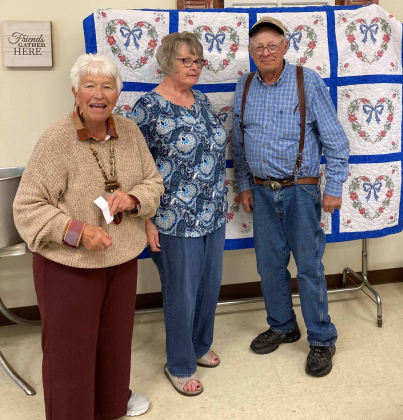 During the pie and ice cream fundraiser, Judy Winegar (pictured on left) held the drawing for the handmade quilt donated by Sharon DiCarlo (middle), and was won by Chris Christensen (right).